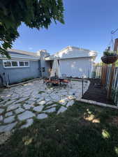 Back of house featuring a chimney, fence, and a patio