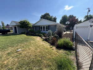 Single story home featuring a front lawn, fence, and a gate