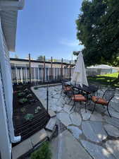 View of patio / terrace with outdoor dining area, fence, and a vegetable garden