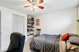 Carpeted bedroom with a closet, a ceiling fan, and baseboards