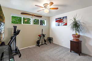 Exercise area featuring carpet, ceiling fan, and baseboards