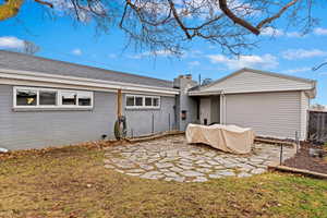 Back of house featuring a shingled roof, a patio, a chimney, and fence