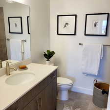 Bathroom with toilet, tile patterned flooring, vanity, and baseboards