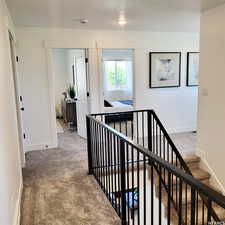 Hallway with carpet flooring and baseboards