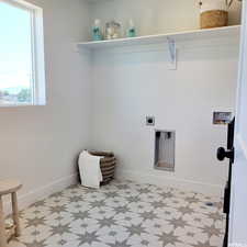 Clothes washing area featuring hookup for a washing machine, laundry area, baseboards, and light floors