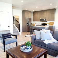 Living area featuring light wood-style flooring, stairway, a textured ceiling, and recessed lighting