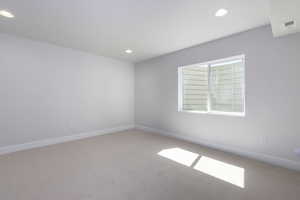 Spare room featuring baseboards, visible vents, carpet flooring, and recessed lighting