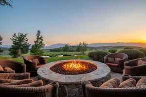 Patio terrace at dusk featuring an outdoor fire pit and a mountain view