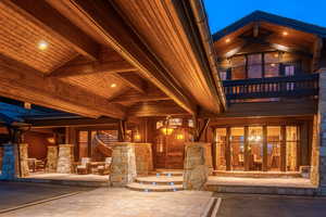 Doorway to property with a balcony and stone siding