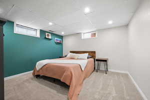 Carpeted bedroom with recessed lighting, a paneled ceiling, and baseboards