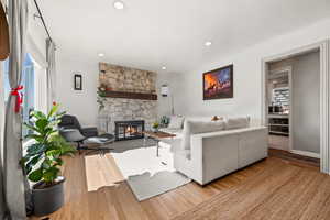 Living room with a fireplace, wood finished floors, and recessed lighting