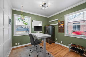 Office area with baseboards, crown molding, visible vents, and wood finished floors