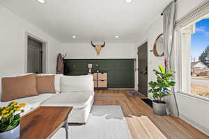 Living area with baseboards, recessed lighting, and light wood-style floors