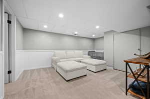 Carpeted living area with recessed lighting, a paneled ceiling, and baseboards