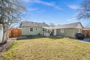 Back of house featuring a patio area, a fenced backyard, and a lawn