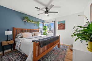 Bedroom with ceiling fan, baseboards, and wood finished floors