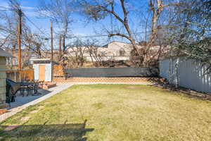 View of yard featuring an outbuilding, a storage unit, a patio area, and a fenced backyard