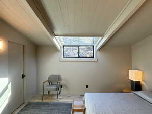 Bedroom with lofted ceiling, wood finished floors, and wood ceiling