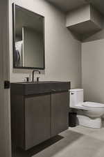 Half bath featuring toilet, washer / clothes dryer, and vanity