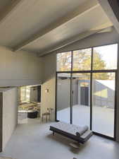 Interior space with concrete flooring, wood ceiling, visible vents, and beam ceiling