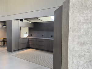 Kitchen featuring modern cabinets and finished concrete floors