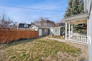 View of yard with fence and an outbuilding