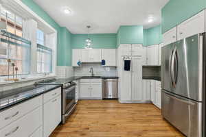 Kitchen featuring stainless steel appliances, dark countertops, and a sink