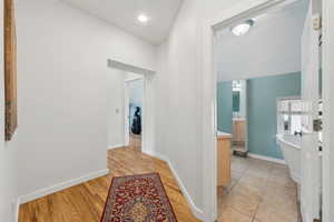 Hallway featuring light wood-style floors and baseboards