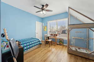 Bedroom featuring lofted ceiling, a ceiling fan, baseboards, and wood finished floors