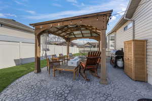 View of patio featuring a fenced backyard, a grill, a gazebo, and an outdoor hangout area