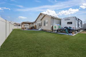 Back of property featuring entry steps, fence private yard, a lawn, and a gazebo