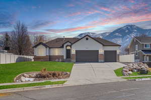 View of front of home featuring brick siding, a front yard, and fence