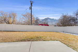 View of yard featuring a patio area, a fenced backyard, and a mountain view