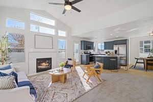 Living area featuring light wood finished floors, ceiling fan, a premium fireplace, high vaulted ceiling, and recessed lighting