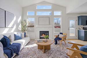 Living room featuring plenty of natural light, a premium fireplace, and high vaulted ceiling