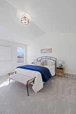 Carpeted bedroom with visible vents, vaulted ceiling, and baseboards