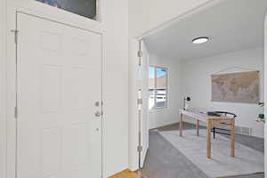 Entrance foyer with light wood-style floors, visible vents, and baseboards