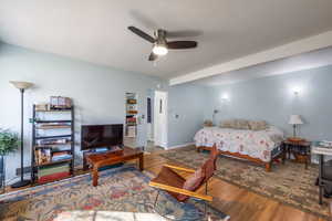 Bedroom featuring wood finished floors, a ceiling fan, and baseboards