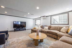 Living area with baseboards, visible vents, ornamental molding, a textured ceiling, and carpet floors