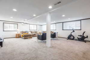 Carpeted living room featuring ornamental molding, recessed lighting, visible vents, and baseboards