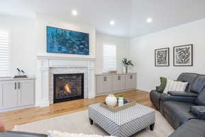 Living area with light wood-style floors, recessed lighting, a fireplace, and baseboards