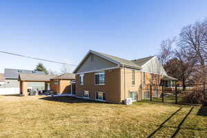 View of home's exterior featuring a patio, a fenced backyard, brick siding, a lawn, and ac unit