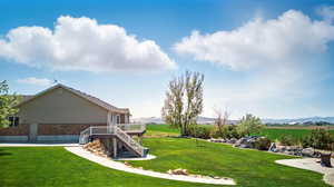 View of yard with stairs and a deck with mountain view