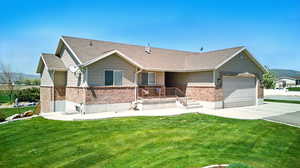 Ranch-style house featuring concrete driveway, a front yard, brick siding, and an attached garage