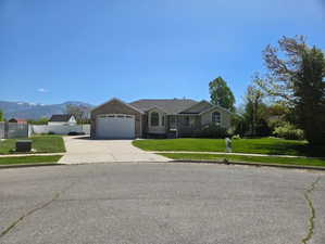 Ranch-style house with concrete driveway, an attached garage, and a mountain view