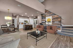 Living area featuring light wood-type flooring, stairway, wooden walls, and recessed lighting