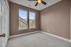 Unfurnished bedroom featuring carpet, a closet, visible vents, a ceiling fan, and baseboards