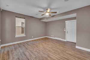 Empty room with light wood-type flooring, visible vents, and baseboards