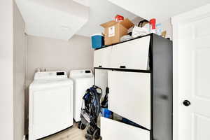 Laundry room with washing machine and dryer, laundry area, and wood finished floors