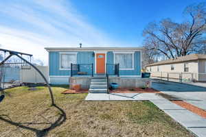 View of front of home with fence, board and batten siding, and a front yard